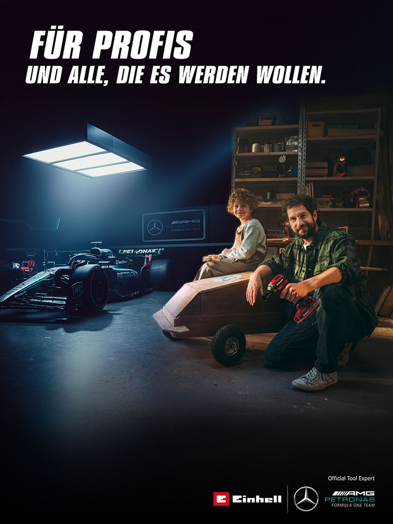 A father and child in a workshop with a homemade soapbox car. In the background, a Mercedes-AMG PETRONAS Formula One car and Einhell tools. Text on the right reads: "For professionals and those who want to become one."