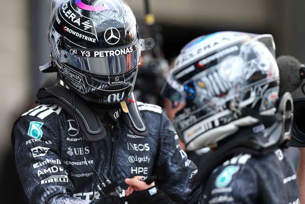 Dva jezdci Mercedes F1 v závodních oblecích a helmách