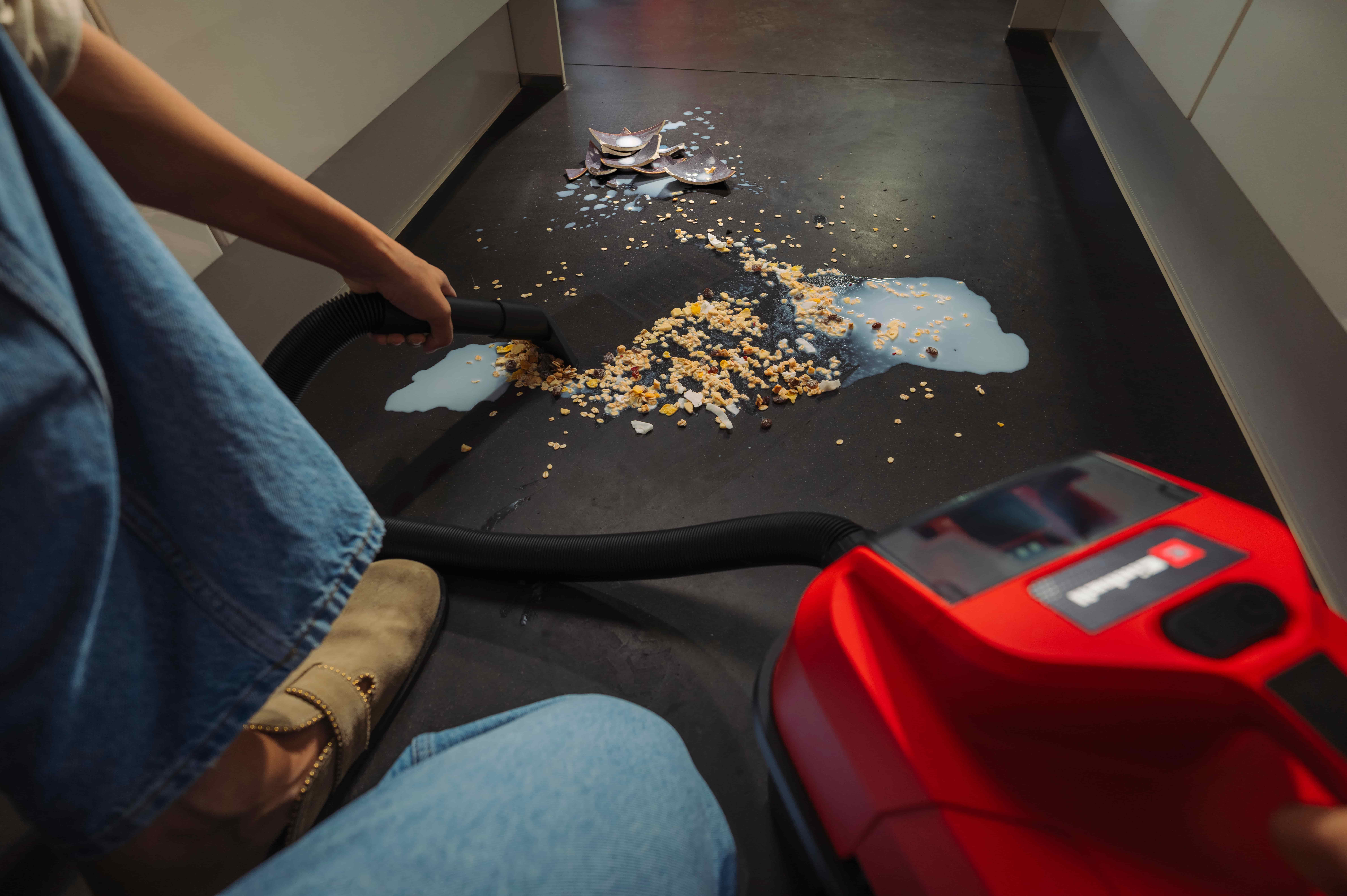 Einhell handheld vacuum cleaning crumbs from a floor at home.