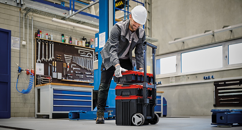 Ein Arbeiter stapelt Einhell E-Cases in einer Werkstatt.