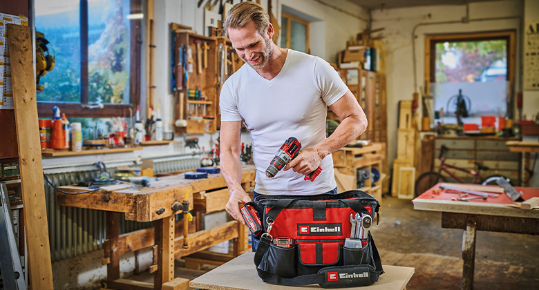 Ein Mann benutzt einen Einhell Werkzeugkoffer in einer Holzwerkstatt.