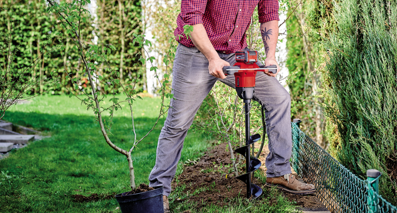 A man using the Einhell earth auger in his garden