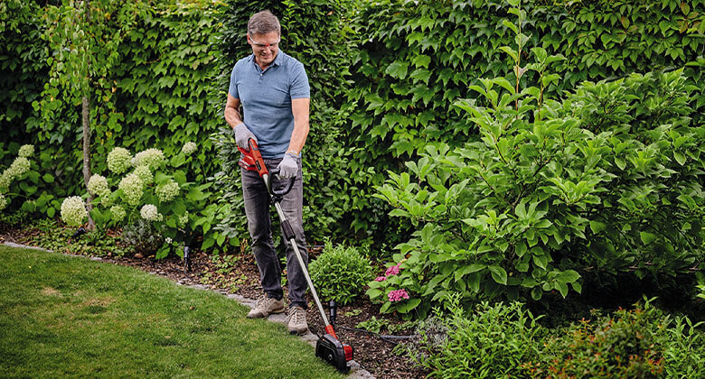 A man trimming the edges in the garden 