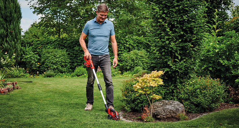 A man trimming the edges in the garden 