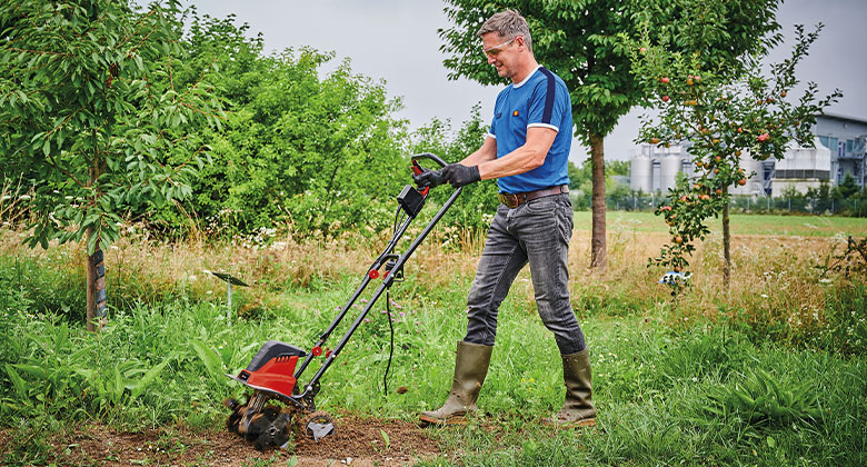 a man hoes the earth in a meadow