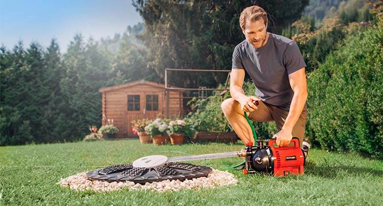a man uses a water pump in the garden